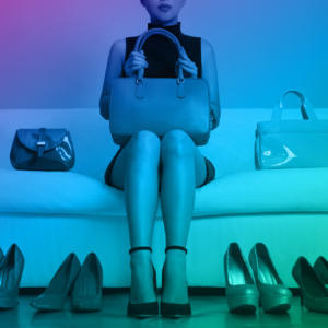 Women sitting on couch surrounded by luxury purses and shoes